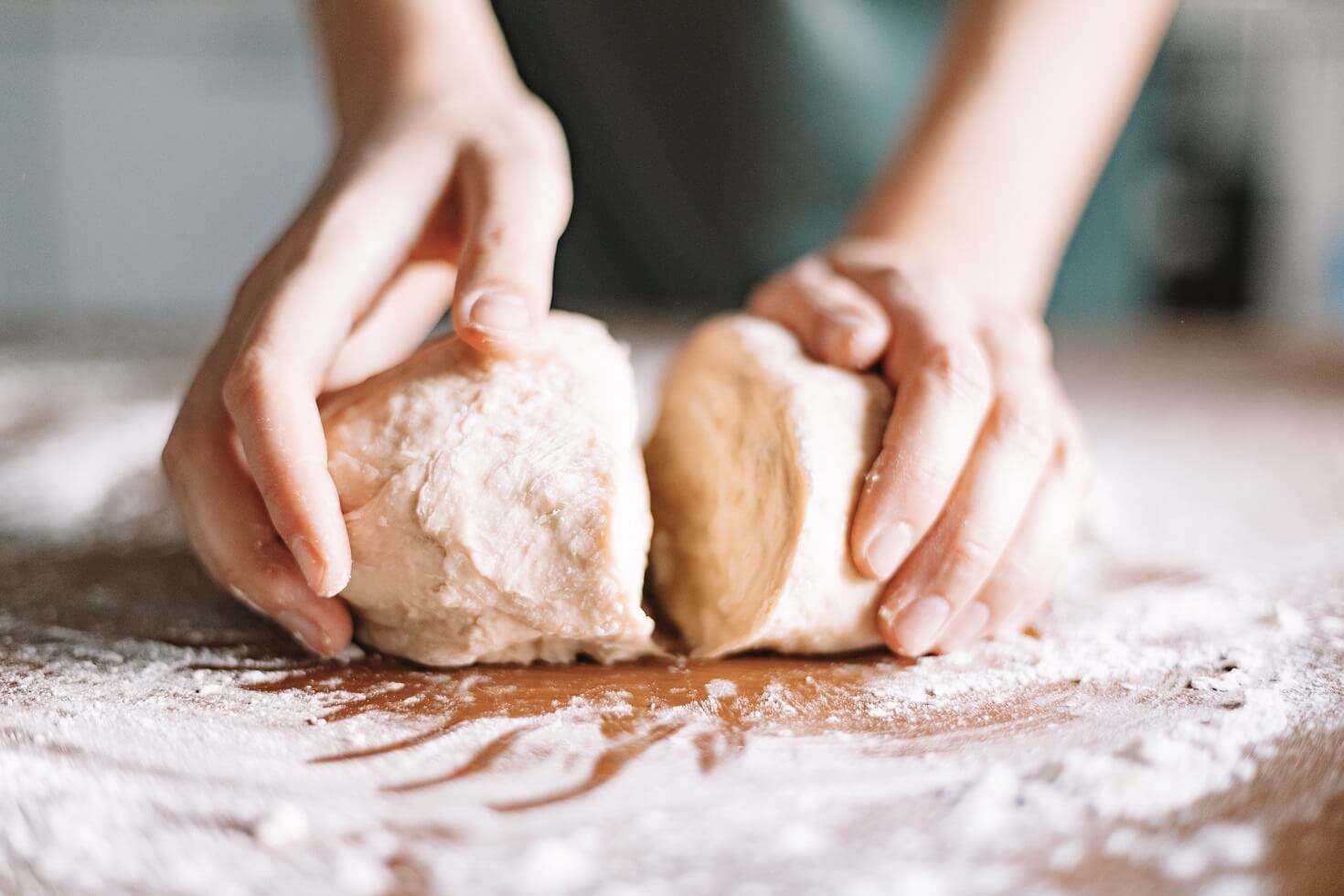 Hands rolling dough with gluten