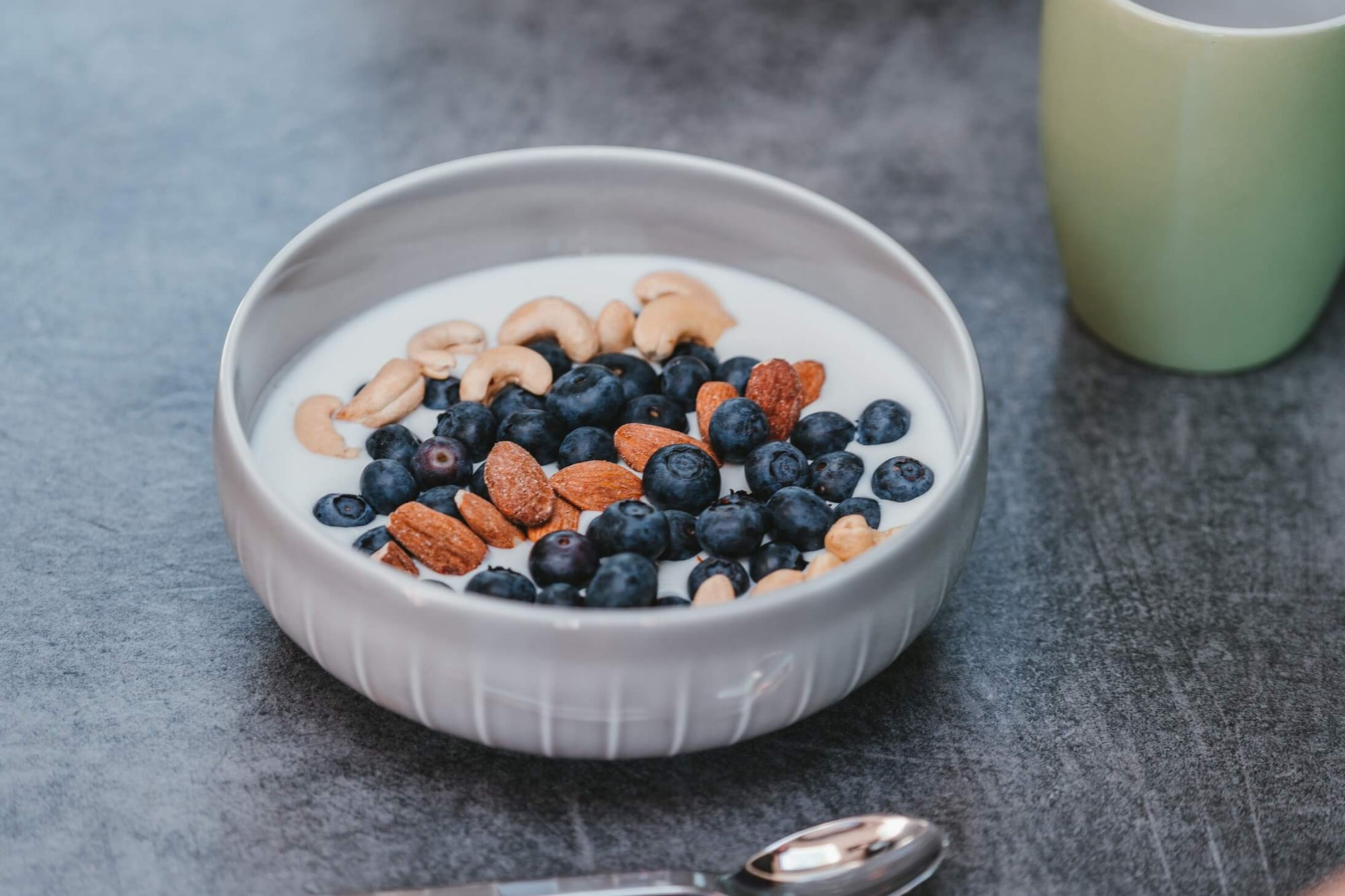 Yogurt in a bowl topped with berries and nuts