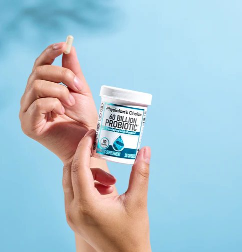 Hand holding a 60 Billion Probiotic capsule next to the bottle
