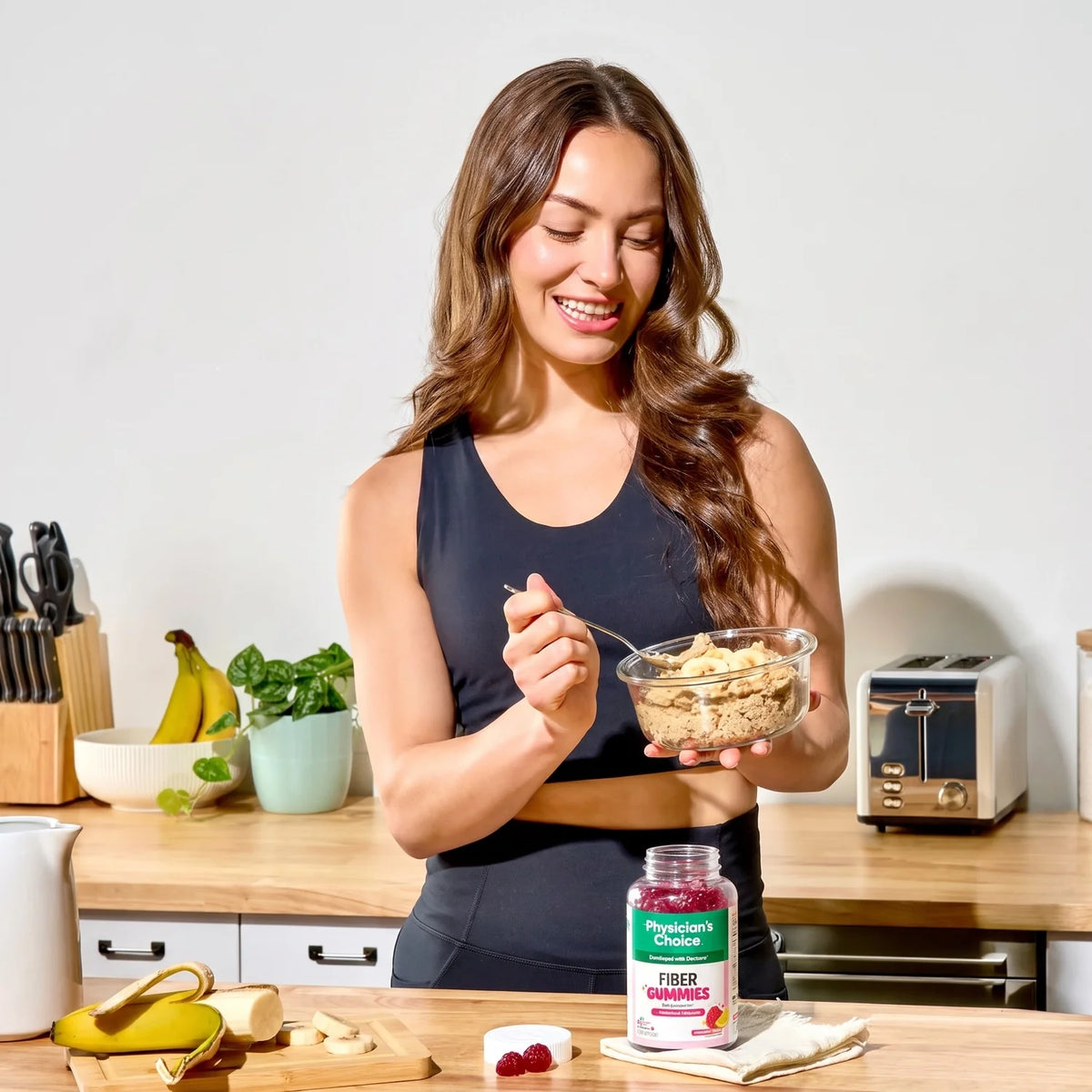 A woman eating breakfast with Fiber Gummies on the counter