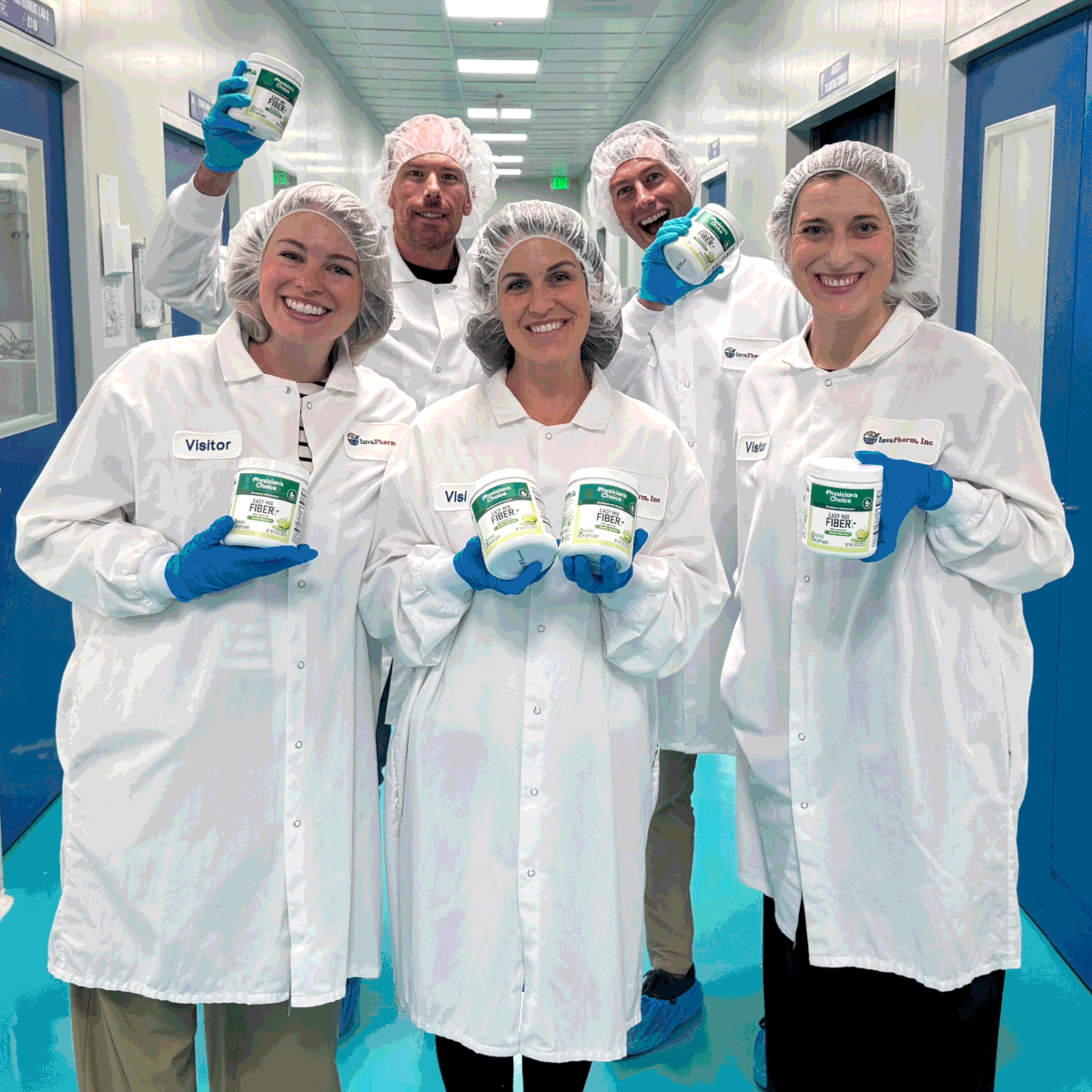 Physician's Choice team inside the manufacturing cleanroom holding finished Fiber tubs